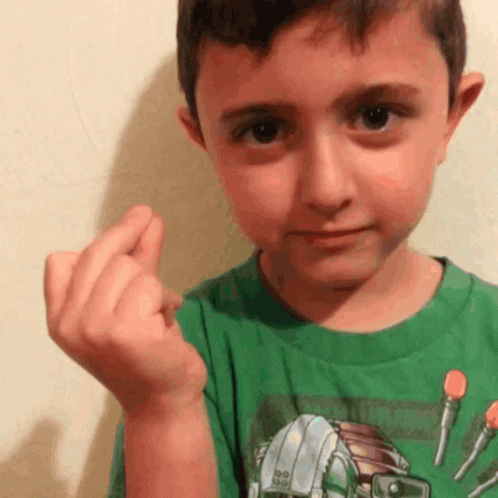 A Young Boy In A Green Shirt With A Robot On It GIF
