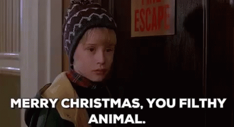 A Young Boy In A Hat Is Standing In Front Of A Door And Says `` Merry Christmas , You Filthy Animal . '' GIF