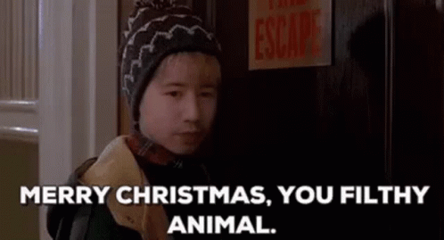 A Young Boy In A Hat Is Standing In Front Of A Door . GIF