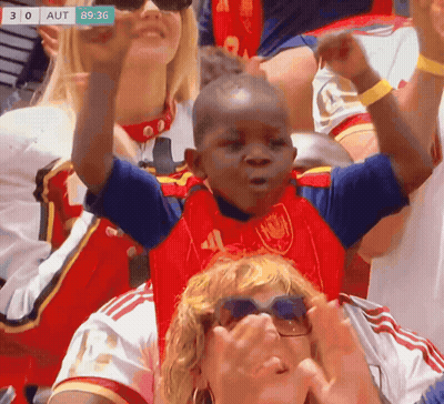 A Young Boy In A Red And Blue Shirt With The Number 41 On It Is Cheering In A Crowd GIF