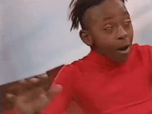 A Young Boy In A Red Shirt Is Making A Funny Face With His Eyes Closed And His Mouth Open . GIF
