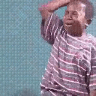 A Young Boy In A Striped Shirt Is Crying While Holding His Hand To His Forehead . GIF