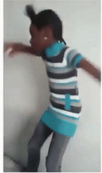 A Young Boy In A Striped Shirt Is Dancing GIF