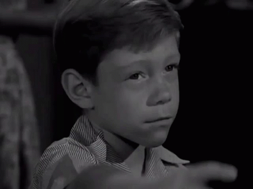 A Young Boy In A Striped Shirt Is Pointing His Finger GIF