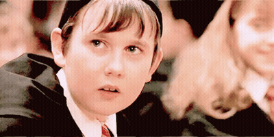 A Young Boy In A Suit And Tie Is Looking Up At Something . GIF