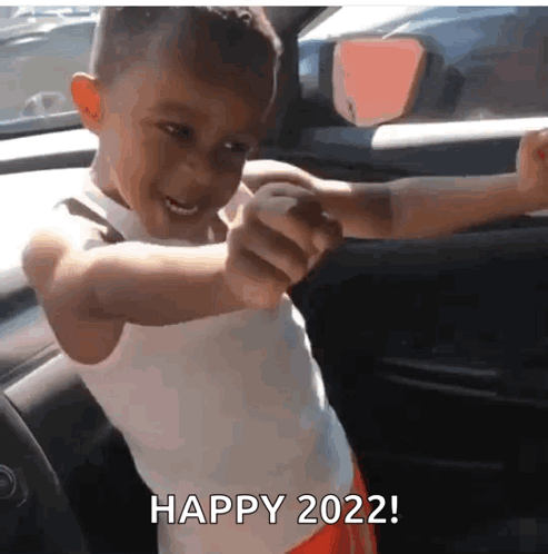 A Young Boy In A White Tank Top Is Pointing At The Camera And Says Happy 2022 . GIF