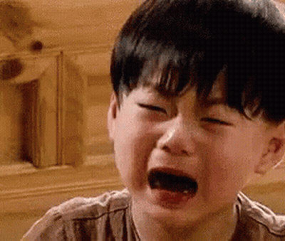 A Young Boy Is Crying With His Mouth Open In A Close Up Of His Face . GIF