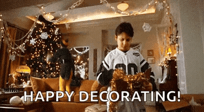 A Young Boy Is Decorating A Living Room For Christmas . GIF