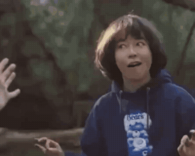 A Young Boy Is Giving A High Five To Another Person While Holding A Bag Of Beans . GIF