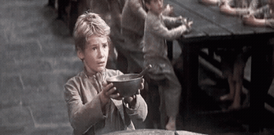 A Young Boy Is Holding A Bowl Of Food In His Hands . GIF