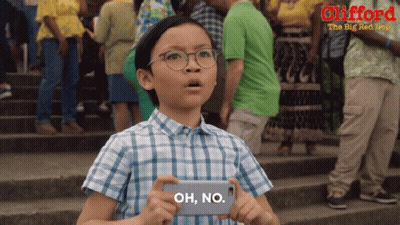 A Young Boy Is Holding A Cell Phone That Says Oh No On It GIF