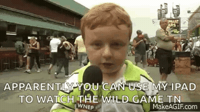 A Young Boy Is Holding A Microphone And Talking Into It While Standing In Front Of A Crowd . GIF