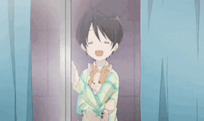 A Young Boy Is Holding A Small Dog In His Arms . GIF