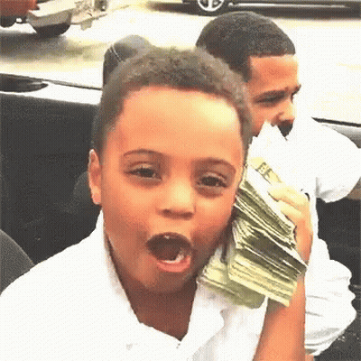 A Young Boy Is Holding A Stack Of Money In Front Of His Face . GIF