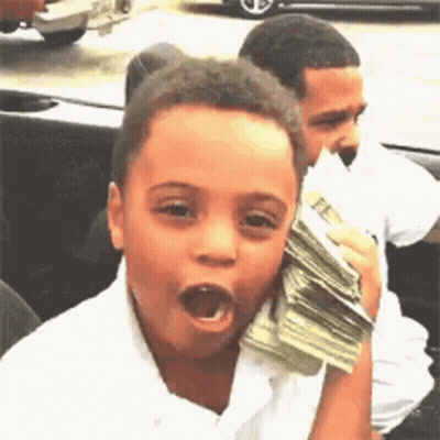 A Young Boy Is Holding A Stack Of Money In His Hand And Making A Funny Face . GIF