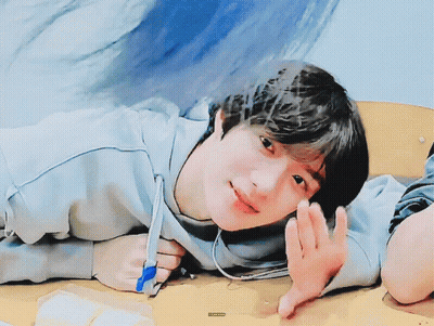 A Young Boy Is Laying On A Table With A Pen In His Hand And A Sticker That Says ' A ' On It GIF