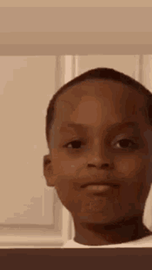 A Young Boy Is Making A Funny Face In A Room . GIF