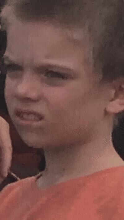 A Young Boy Is Making A Funny Face While Looking At The Camera . GIF