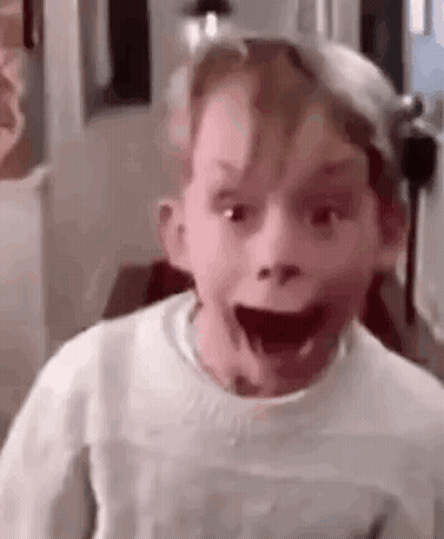 A Young Boy Is Making A Funny Face With His Mouth Open And His Eyes Closed . GIF