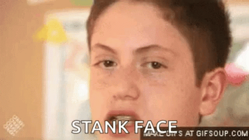 A Young Boy Is Making A Funny Face With His Mouth Open And The Words Stank Face At The Bottom . GIF