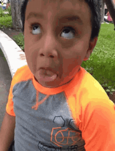 A Young Boy Is Making A Funny Face With His Tongue Out . GIF