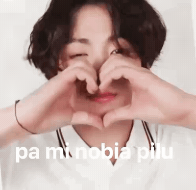 A Young Boy Is Making A Heart Shape With His Hands . GIF