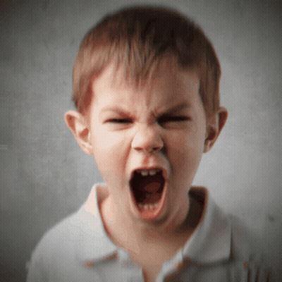 A Young Boy Is Making A Very Angry Face With His Mouth Open GIF