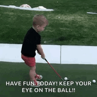 A Young Boy Is Playing Golf On A Green And Holding A Golf Club . GIF