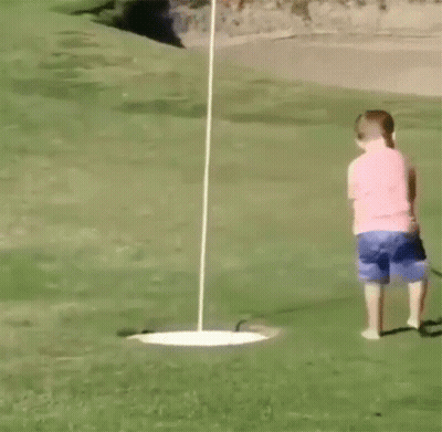 A Young Boy Is Playing Golf On A Green GIF