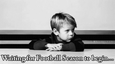 A Young Boy Is Sitting At A Table Waiting For Football Season To Begin . GIF