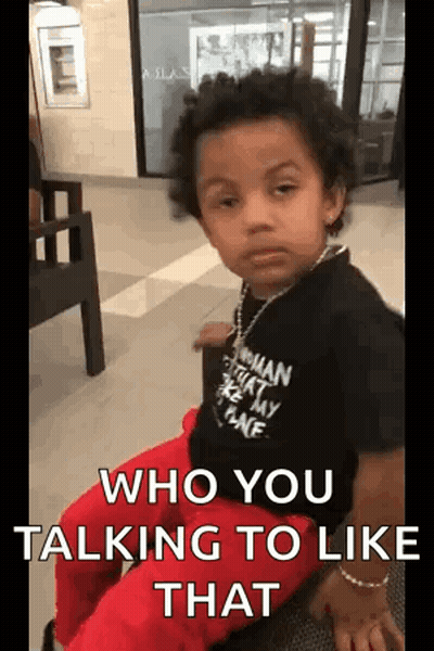 A Young Boy Is Sitting In A Chair With A Necklace Around His Neck And Says `` Who You Talking To Like That '' . GIF