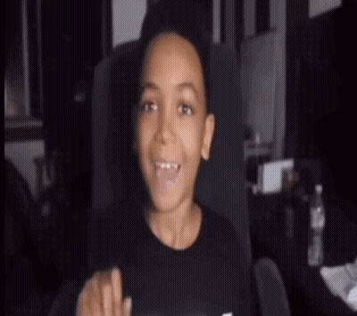 A Young Boy Is Sitting In A Chair With His Mouth Open And A Bottle Of Water In The Background . GIF