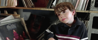 A Young Boy Is Sitting In Front Of A Burn Record GIF
