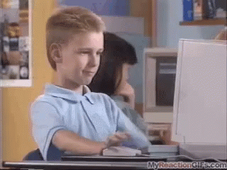 A Young Boy Is Sitting In Front Of A Computer Monitor . GIF