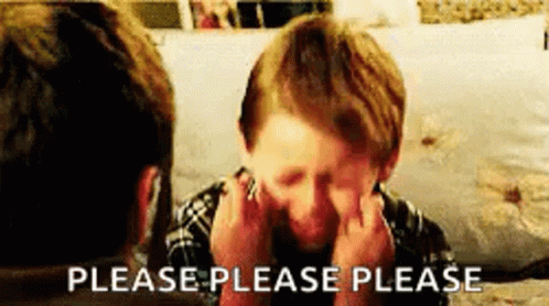 A Young Boy Is Sitting In Front Of A Man Covering His Face With His Hands . GIF