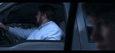 A Young Boy Is Sitting In The Back Seat Of A Red Car GIF