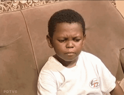 A Young Boy Is Sitting On A Couch With His Eyes Closed GIF