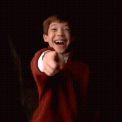A Young Boy Is Smiling While Holding A Can Of Soda . GIF