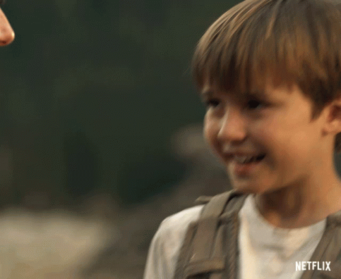 A Young Boy Is Smiling With A Netflix Logo In The Corner GIF