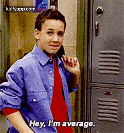 A Young Boy Is Standing In Front Of A Locker And Talking On A Cell Phone . GIF