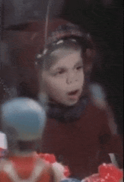 A Young Boy Is Standing Next To A Toy That Has The Letter V On It GIF