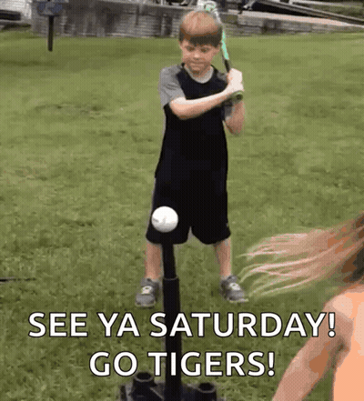 A Young Boy Is Swinging A Bat At A Baseball While A Woman Watches And Says See Ya Saturday Go Tigers ! GIF