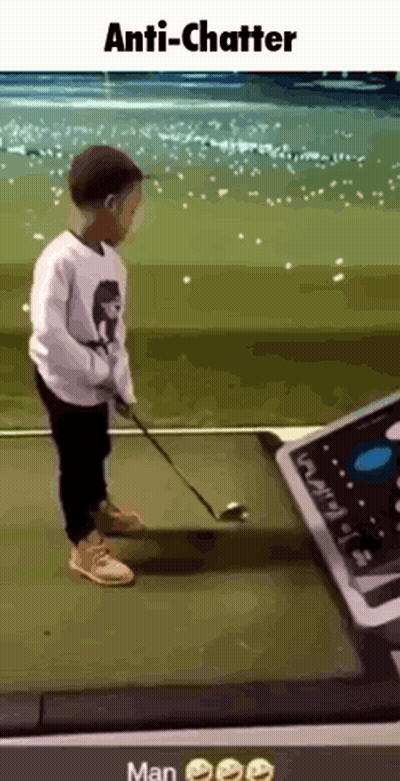 A Young Boy Is Swinging A Golf Club On A Golf Course While Wearing A Face Mask . GIF