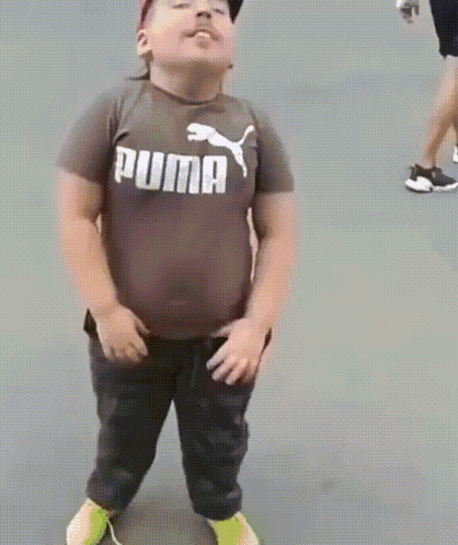 A Young Boy Is Wearing A Puma Shirt And Dancing GIF