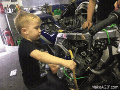 A Young Boy Is Working On A Motorcycle With A Makeagif.com Watermark GIF