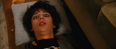 A Young Boy Laying On A Couch With His Mouth Open And A Black Shirt With A Skeleton On It GIF