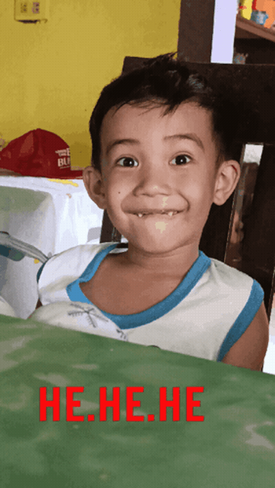 A Young Boy Making A Funny Face With The Words He.he.he. In Red Behind Him GIF
