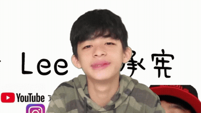 A Young Boy Stands In Front Of A Sign That Says Lee GIF