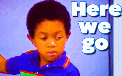 A Young Boy Stands In Front Of A Wall That Says Here We Go GIF