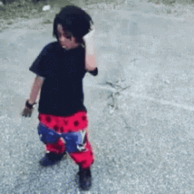 A Young Boy Wearing A Black Shirt And Red And Blue Pants GIF